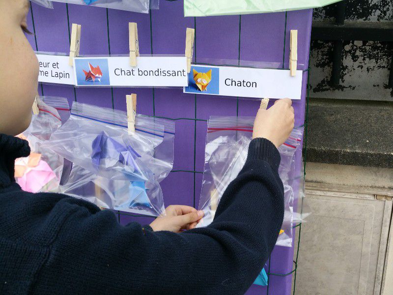 Un enfant choisit un origami dans le distributeur