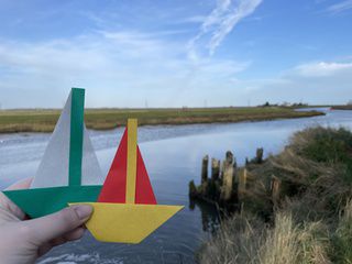 Origami boats sailing in Faversham Creek, Kent, UK