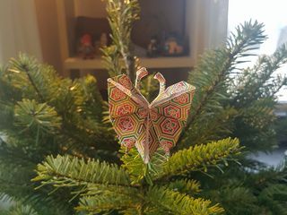 An origami butterfly lands in a Christmas Tree by Mathieu Gueros